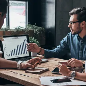 Three People Talking About A Diagram On A Notebook
