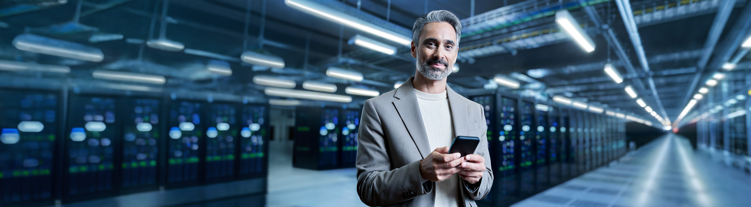 Man With Cellphone In Suit In Data Center In Blue Light