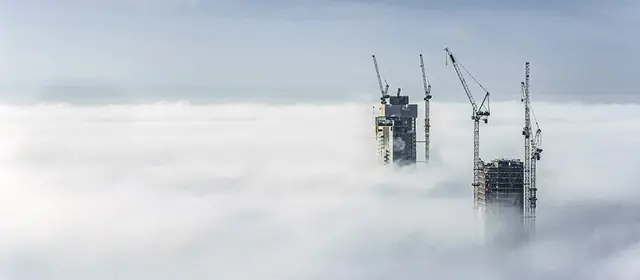 Construction Sites Of High Rise Buildings Protrude From A Blanket Of Clouds