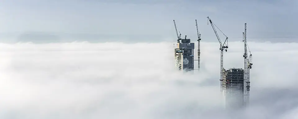 Construction Sites Of High Rise Buildings Protrude From A Blanket Of Clouds
