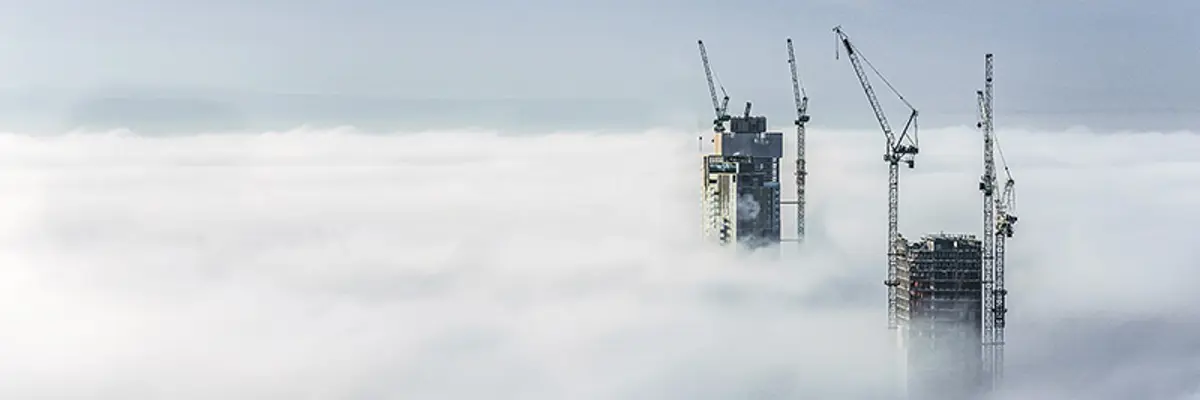 Construction Sites Of High Rise Buildings Protrude From A Blanket Of Clouds