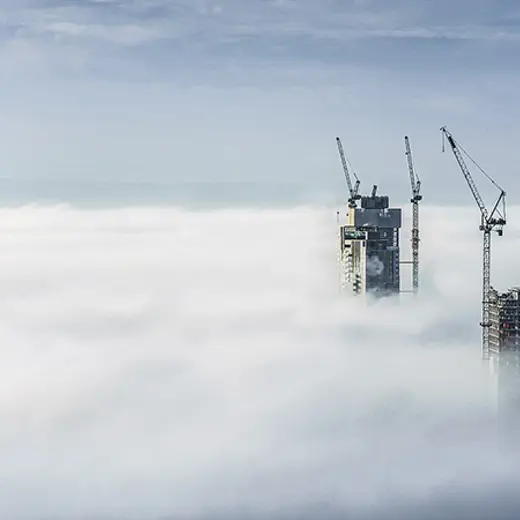 Construction Sites Of High Rise Buildings Protrude From A Blanket Of Clouds