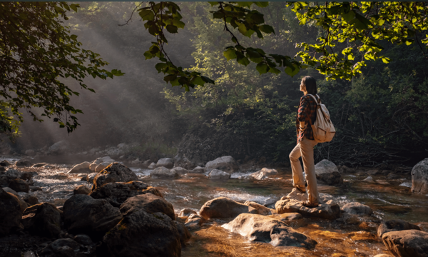 Woman Standing On A Rock In A River