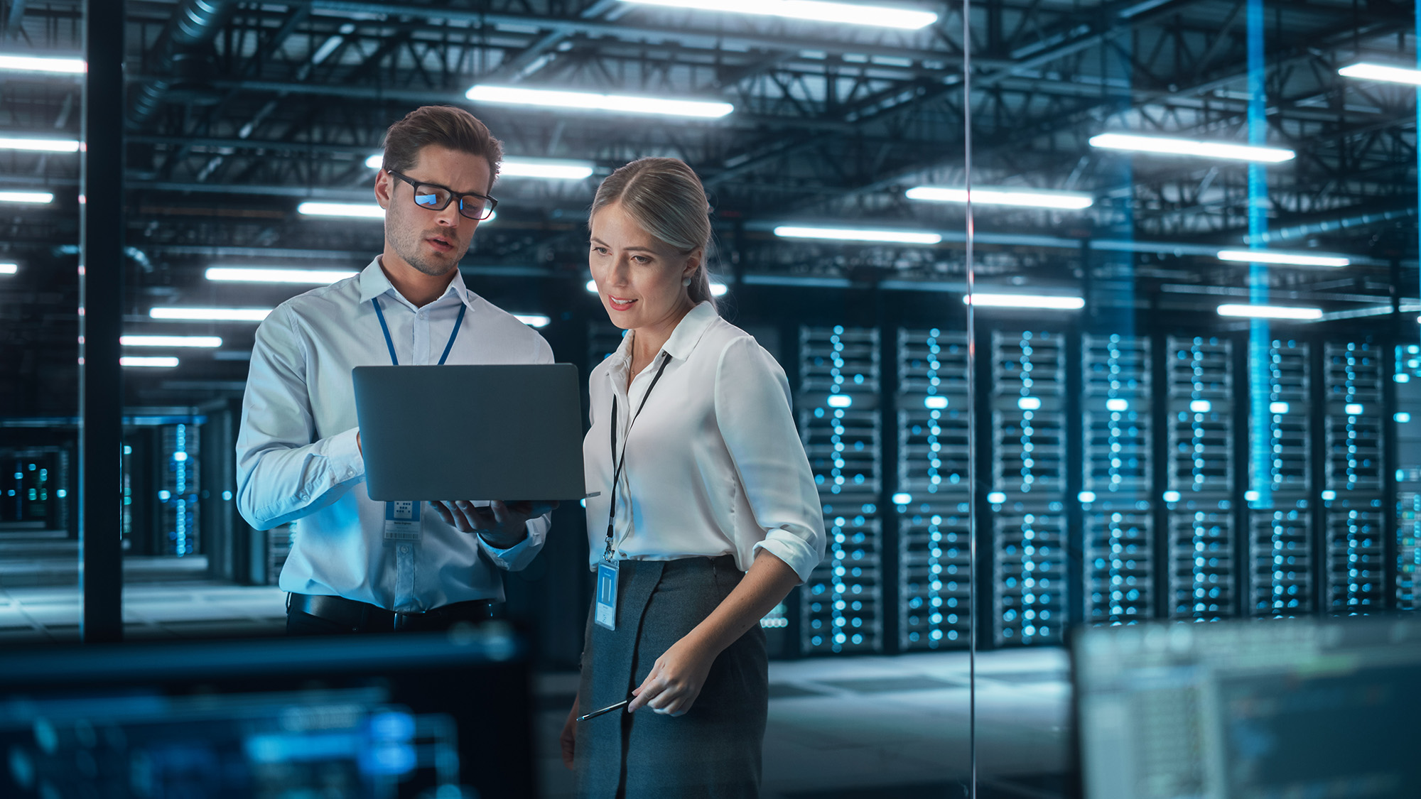 Woman And Man Looking At Laptop In Data Center