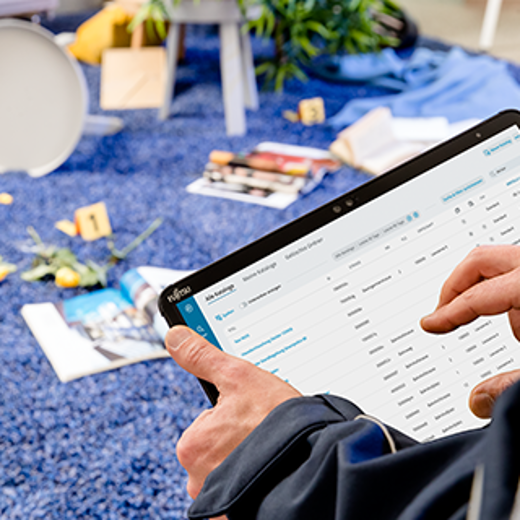 A Person Interacts With A Tablet Displaying A Data Management Interface, Surrounded By A Colorful, Casual Workspace.