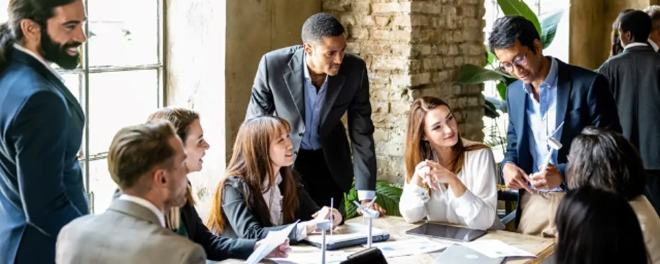 Group Of People Sitting Around A Table