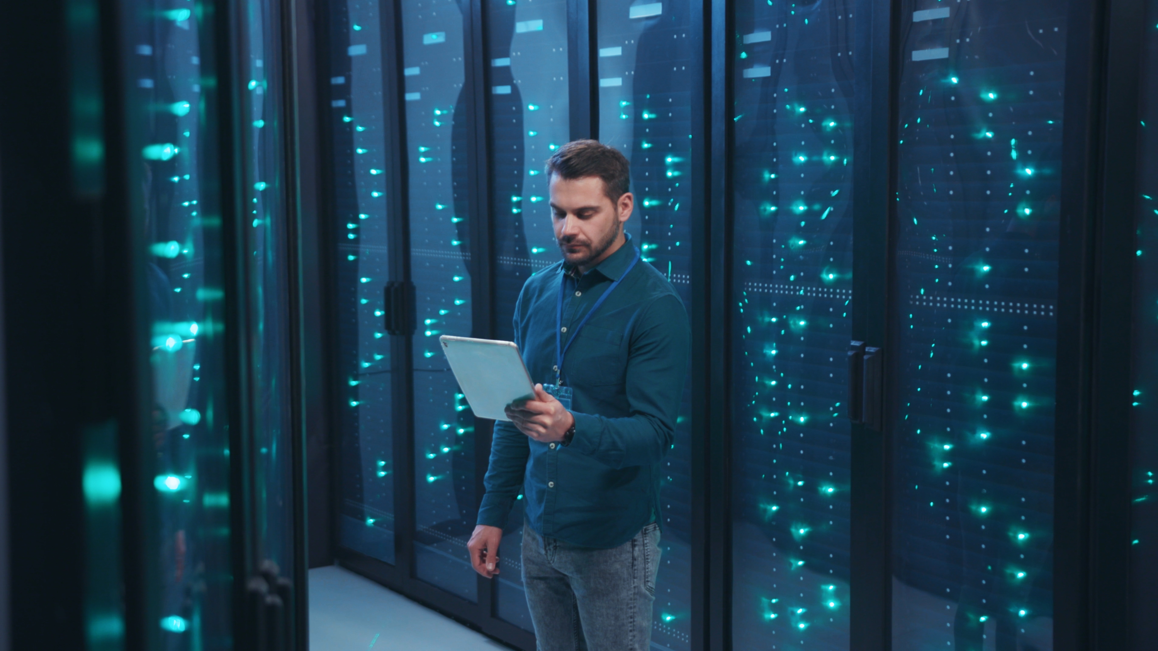 Man With Tablet in a dark data center