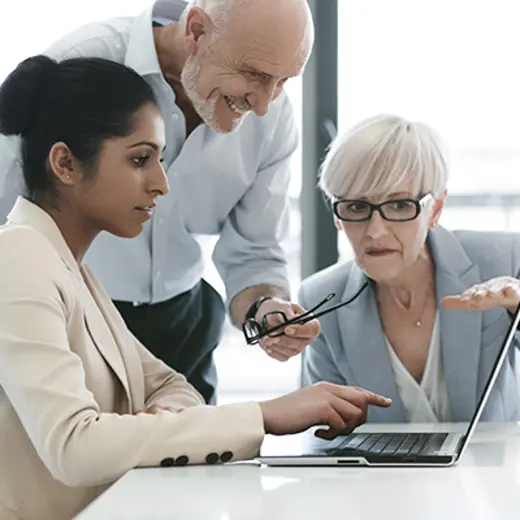 Three People Collaborate Around Laptop