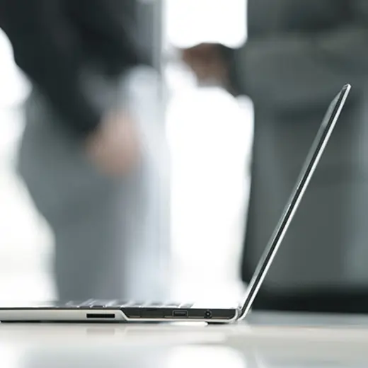 Laptop On Table With Blurred People In Background
