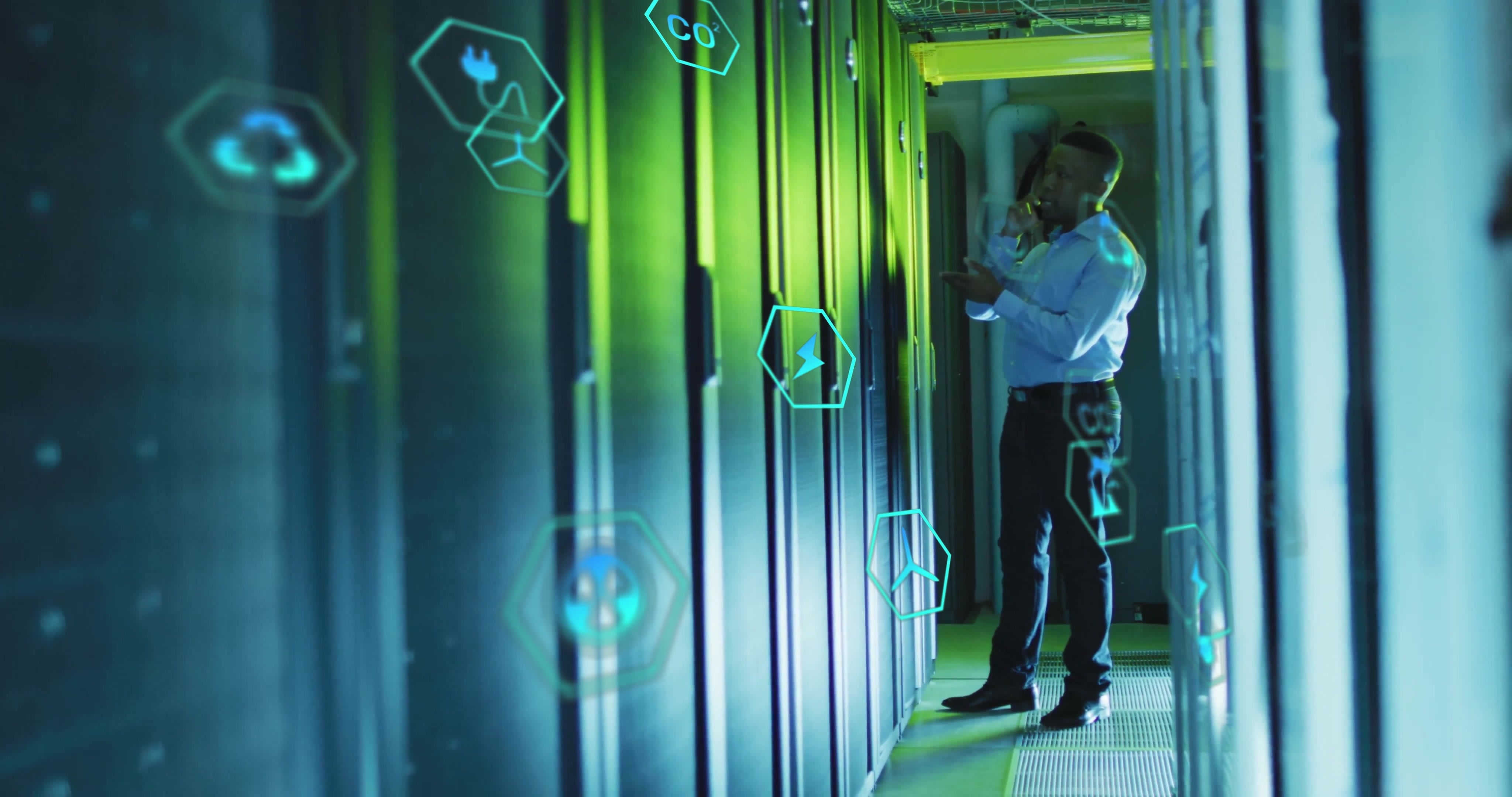 Man in Data Center on mobile phone surrounded by illumniated digital icons