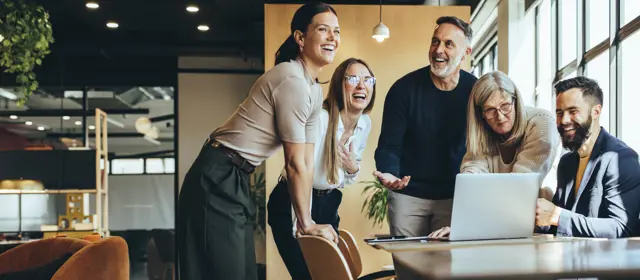 Group Of People In Office Around Laptop