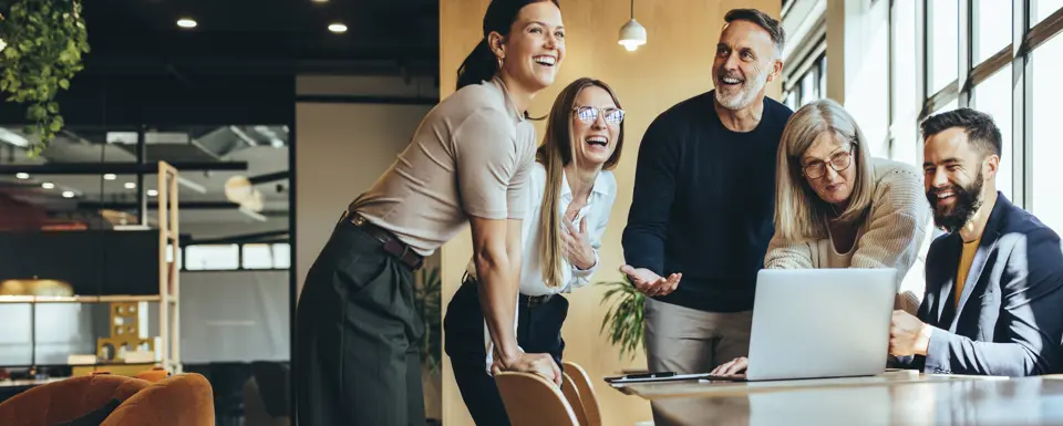 Group Of People In Office Around Laptop