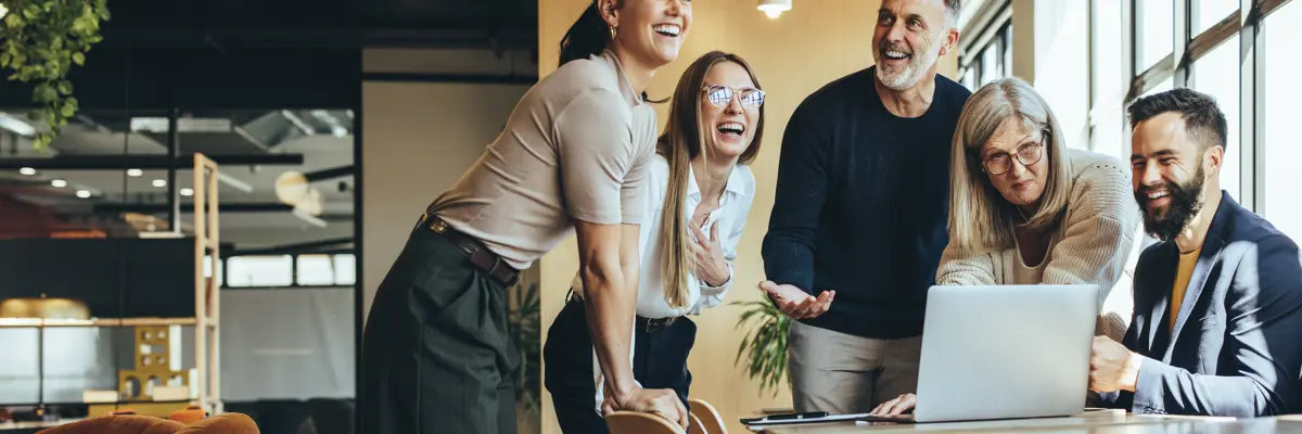 Group Of People In Office Around Laptop